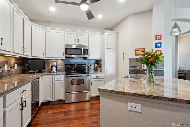 kitchen with pendant lighting, dark wood-type flooring, appliances with stainless steel finishes, white cabinetry, and tasteful backsplash