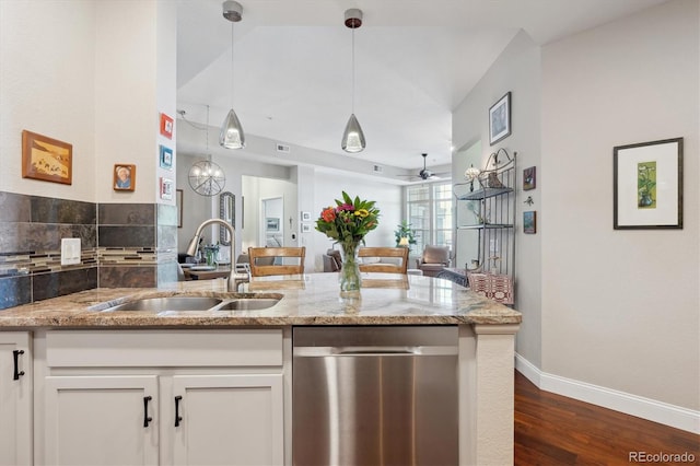 kitchen featuring pendant lighting, dishwasher, sink, white cabinets, and light stone counters