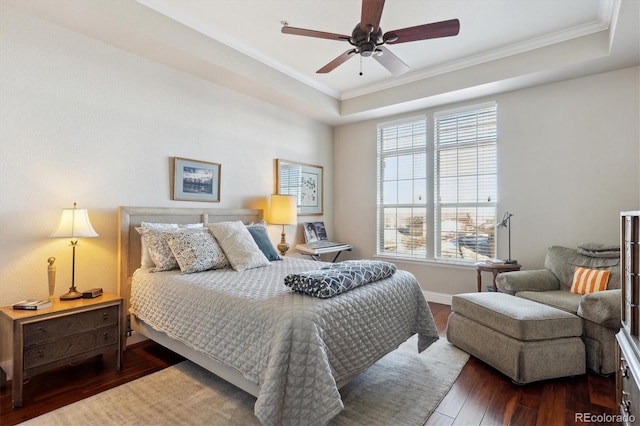 bedroom with dark wood-type flooring, ceiling fan, a raised ceiling, and multiple windows