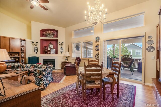 dining space with light hardwood / wood-style floors and ceiling fan with notable chandelier