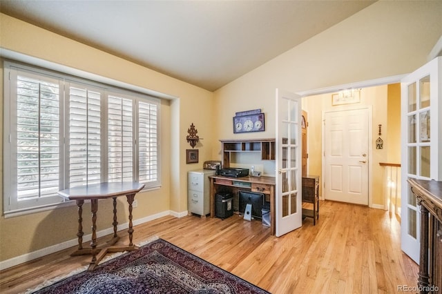 home office featuring french doors, light hardwood / wood-style flooring, plenty of natural light, and lofted ceiling