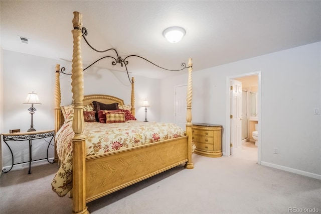 bedroom featuring ensuite bathroom and carpet floors