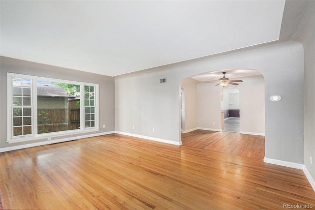 8525 Grandview Ave, Arvada, CO 80002 - spare room featuring arched walkways, ceiling fan, and light wood-type flooring