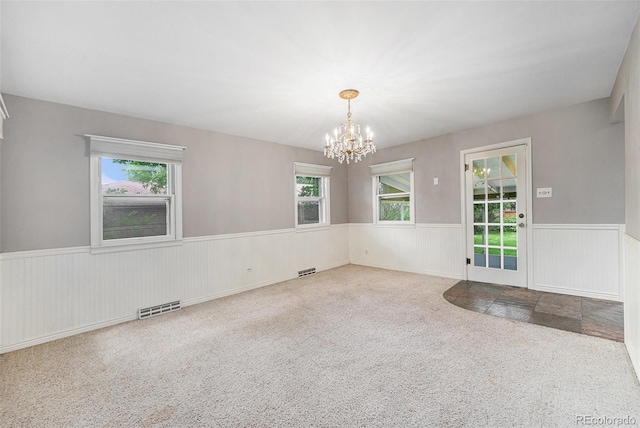 8525 Grandview Ave, Arvada, CO 80002 - unfurnished room with carpet flooring, a chandelier, wainscoting, and healthy amount of natural light