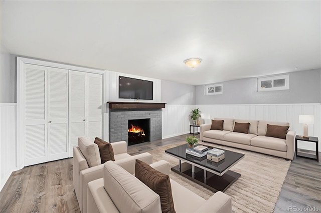 8525 Grandview Ave, Arvada, CO 80002 - living area featuring wood finished floors, a brick fireplace, and wainscoting