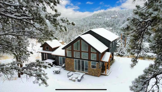 518 Conifer Dr, Bailey, CO 80421 - snow covered house with stone siding and a patio area