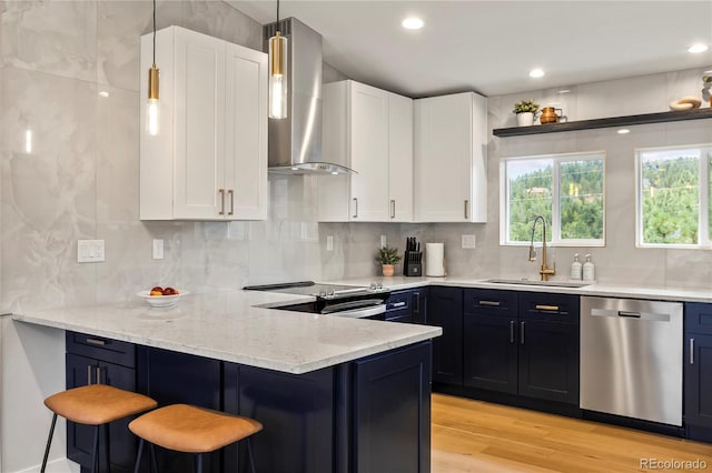 518 Conifer Dr, Bailey, CO 80421 - kitchen with stainless steel appliances, wall chimney exhaust hood, white cabinetry, a breakfast bar, and recessed lighting