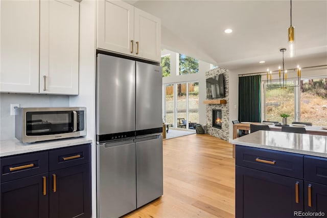 518 Conifer Dr, Bailey, CO 80421 - kitchen featuring stainless steel appliances, white cabinets, a chandelier, light wood-type flooring, and lofted ceiling