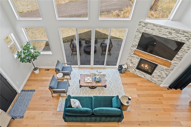 518 Conifer Dr, Bailey, CO 80421 - living room with wood finished floors, a glass covered fireplace, and a high ceiling