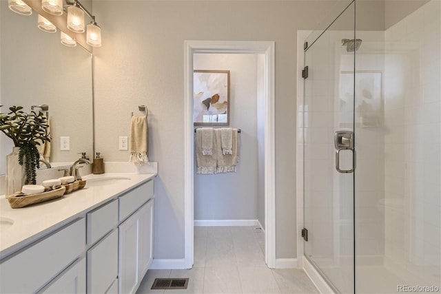 bathroom with tile patterned flooring, vanity, and walk in shower