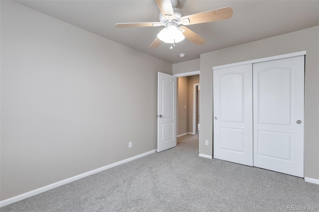 unfurnished bedroom featuring light carpet, a closet, a ceiling fan, and baseboards