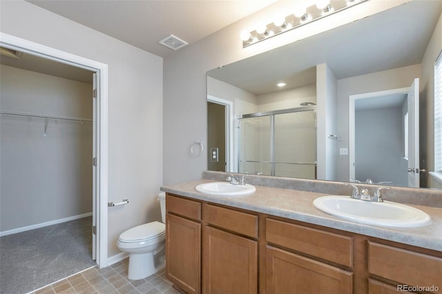 full bathroom featuring a shower stall, a spacious closet, visible vents, and a sink