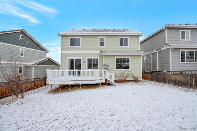 snow covered property with fence private yard and a deck