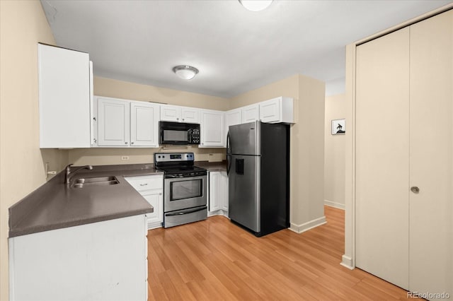 720 S Clinton St Unit 1B, Denver, CO 80247 - kitchen with stainless steel appliances, a sink, dark countertops, and white cabinetry