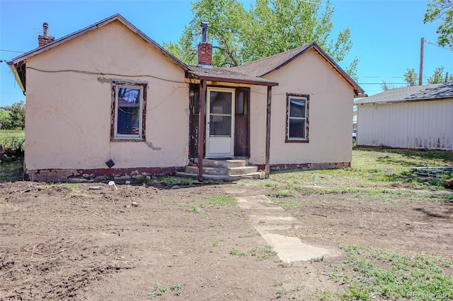 327 E 7th St, Walsenburg, CO 81089 - view of front of house featuring a chimney and stucco siding