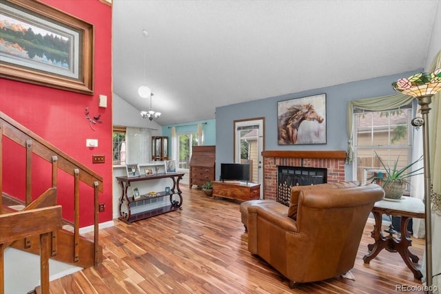 13341 Birch Cir, Thornton, CO 80241 - living area with a fireplace, wood finished floors, vaulted ceiling, and a chandelier