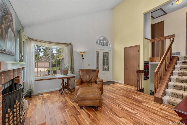 13341 Birch Cir, Thornton, CO 80241 - living area featuring stairs, hardwood / wood-style flooring, a fireplace, and high vaulted ceiling