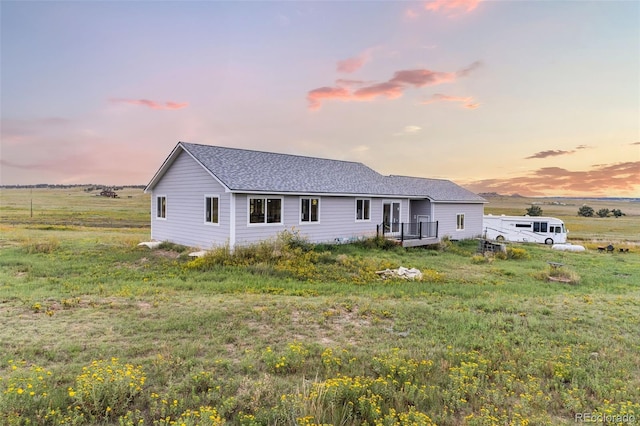 rear view of property featuring roof with shingles