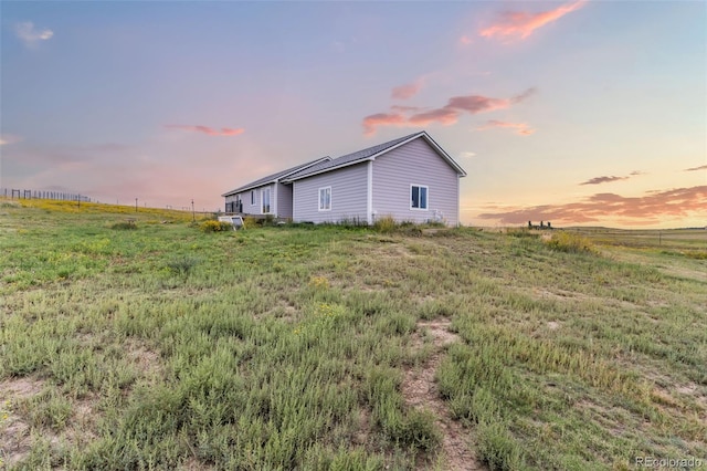 property exterior at dusk featuring a rural view