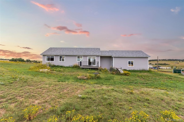 view of front of house featuring a lawn and a wooden deck