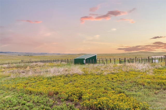 exterior space with fence, a pole building, an outdoor structure, and a rural view