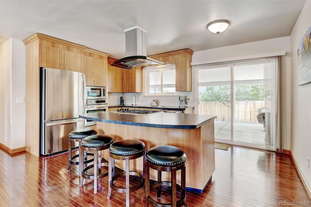 5986 Dunraven St, Golden, CO 80403 - kitchen with stainless steel appliances, island range hood, dark countertops, dark wood-style floors, and a center island