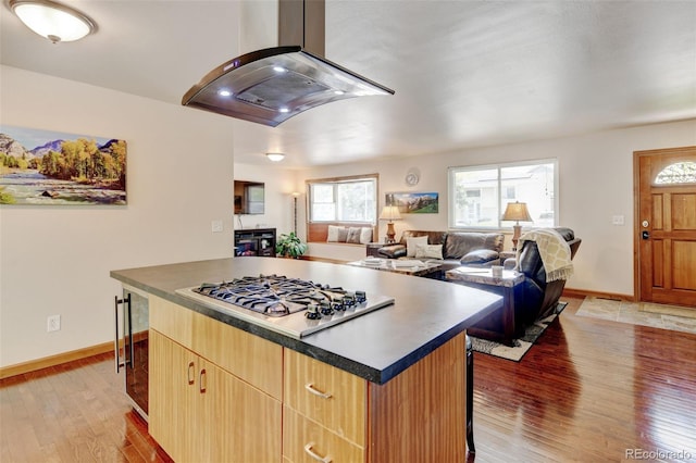 5986 Dunraven St, Golden, CO 80403 - kitchen featuring stainless steel gas stovetop, island exhaust hood, open floor plan, and baseboards