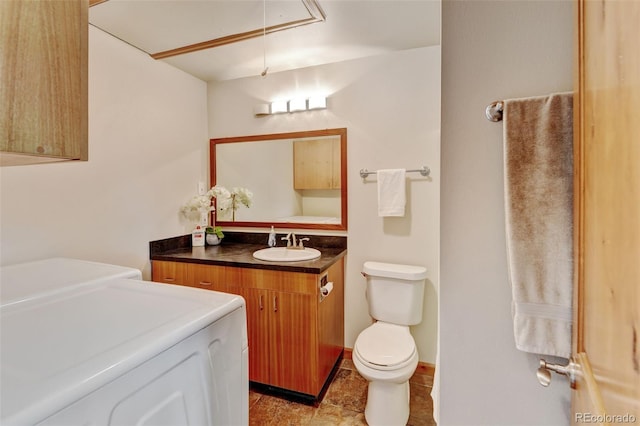 5986 Dunraven St, Golden, CO 80403 - bathroom featuring separate washer and dryer, vanity, and toilet