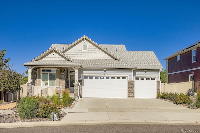 4403 Picadilly Ct, Aurora, CO 80019 - craftsman-style house featuring stone siding, a garage, driveway, a shingled roof, and covered porch