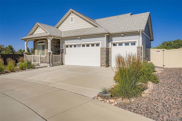 4403 Picadilly Ct, Aurora, CO 80019 - craftsman inspired home featuring stone siding, a garage, concrete driveway, a gate, and a shingled roof