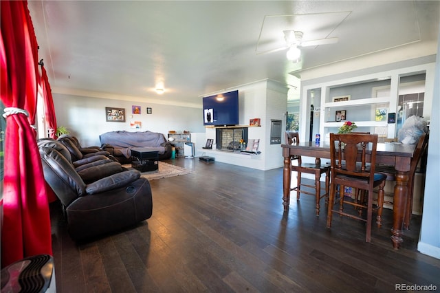 living room with built in shelves, ceiling fan, dark hardwood / wood-style flooring, and a fireplace