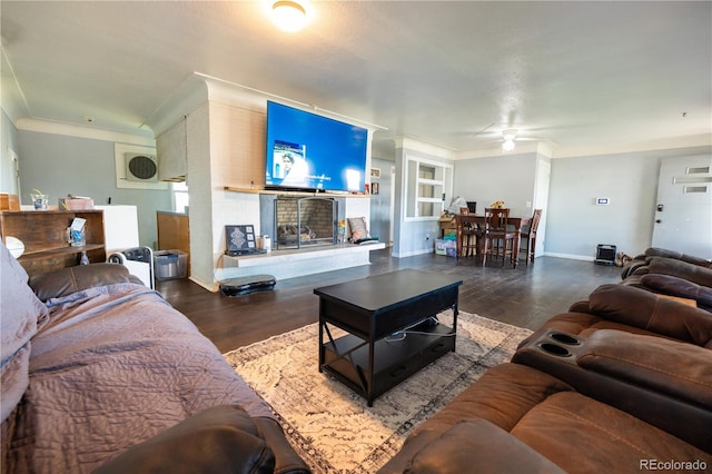 living room featuring crown molding, dark wood-type flooring, and ceiling fan