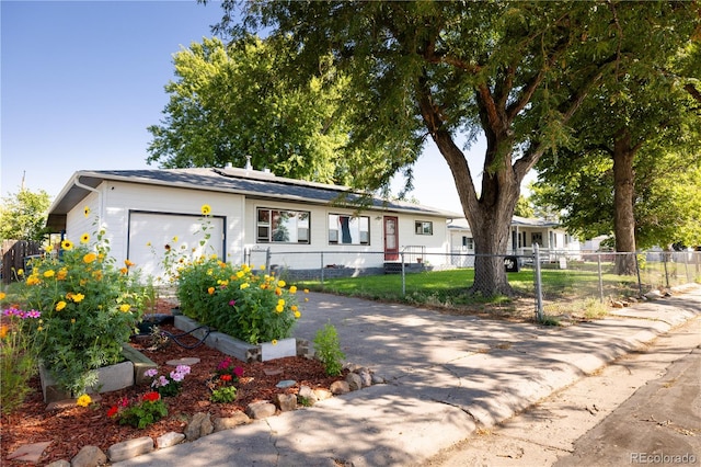 ranch-style home with driveway, an attached garage, and fence