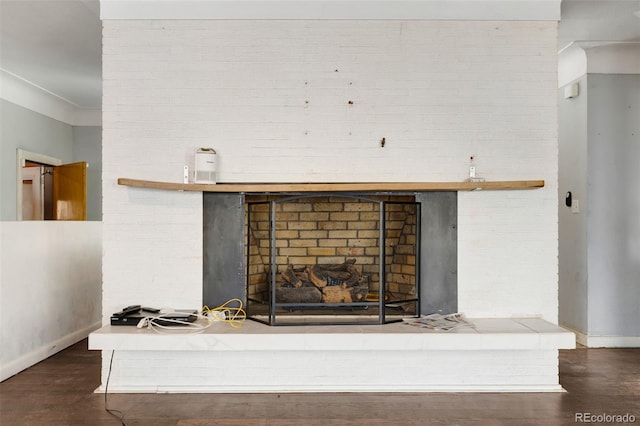 details featuring a fireplace, baseboards, and wood finished floors