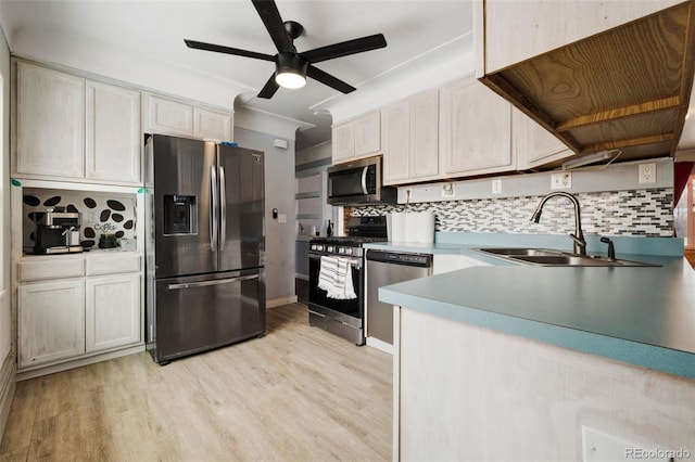 kitchen with decorative backsplash, light wood-style flooring, stainless steel appliances, light countertops, and a sink