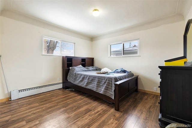 bedroom featuring baseboards, a baseboard heating unit, and dark wood-type flooring