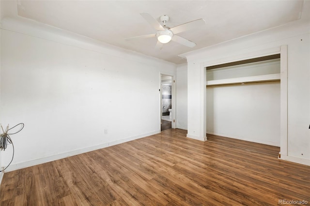 unfurnished bedroom with dark wood-style floors, a closet, baseboards, and a ceiling fan