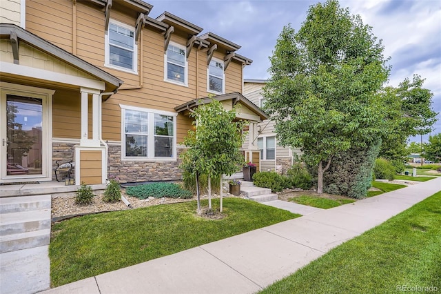 1519 S Dayton St, Denver, CO 80247 - view of front facade with stone siding and a front lawn