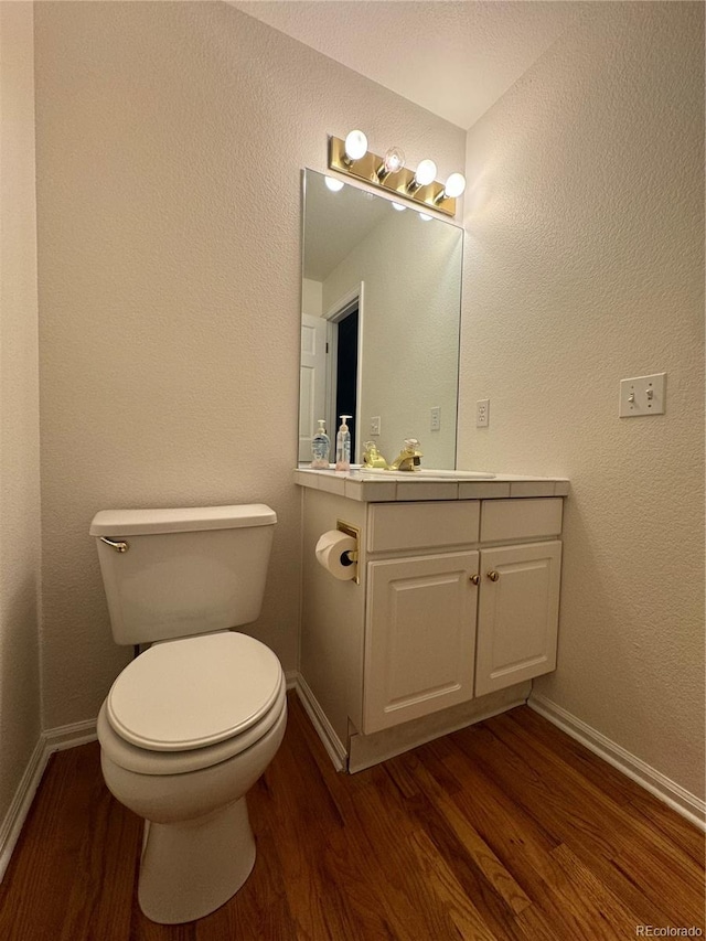 bathroom with vanity, hardwood / wood-style floors, and toilet