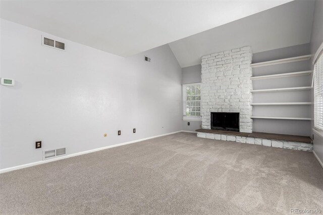 2101 S Victor St Unit C, Aurora, CO 80014 - unfurnished living room featuring carpet, lofted ceiling, and a large fireplace