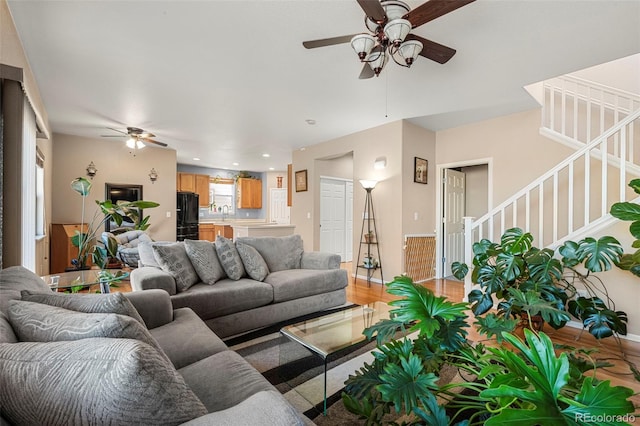 living room with recessed lighting, stairway, light wood-style floors, ceiling fan, and baseboards