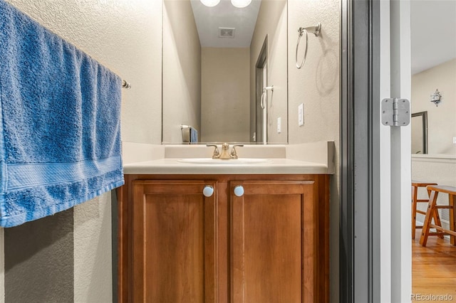 bathroom featuring visible vents, wood finished floors, and vanity