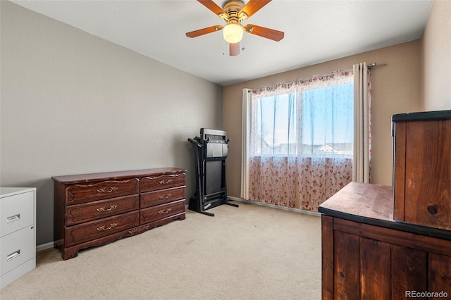 bedroom featuring light carpet, a ceiling fan, and baseboards