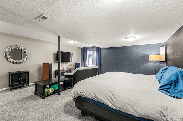 bedroom featuring a textured wall, carpet floors, visible vents, baseboards, and a wood stove