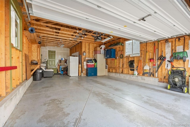 11034 Nome St, Commerce City, CO 80640 - garage featuring freestanding refrigerator and a garage door opener