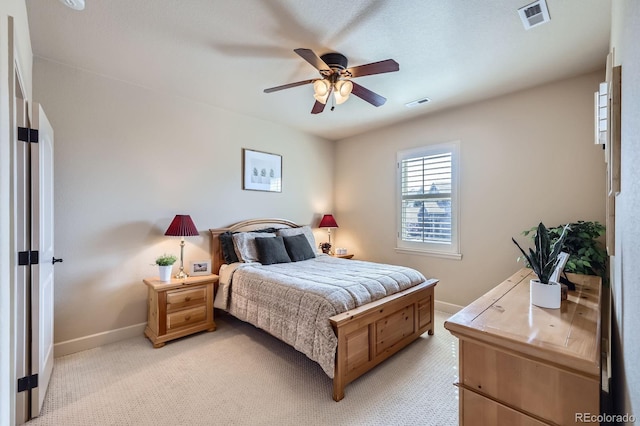bedroom featuring baseboards, ceiling fan, light carpet, and visible vents