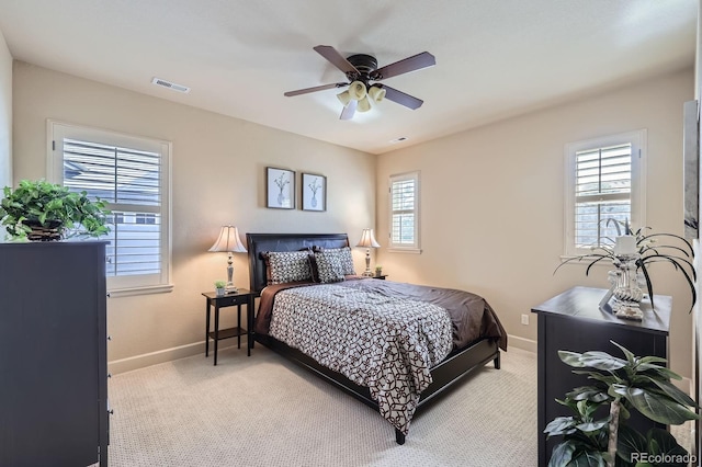 bedroom featuring light colored carpet, baseboards, visible vents, and a ceiling fan