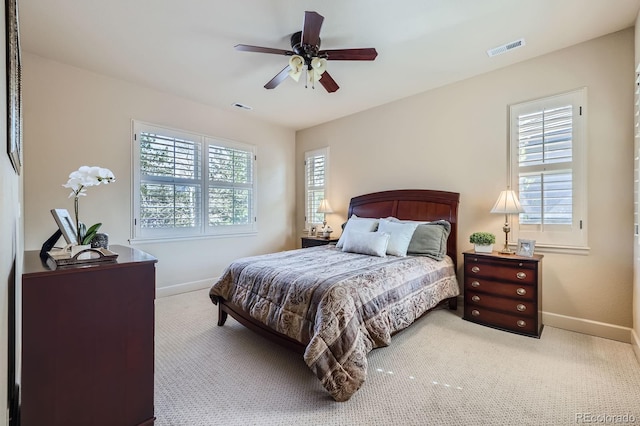 carpeted bedroom featuring baseboards, multiple windows, and visible vents