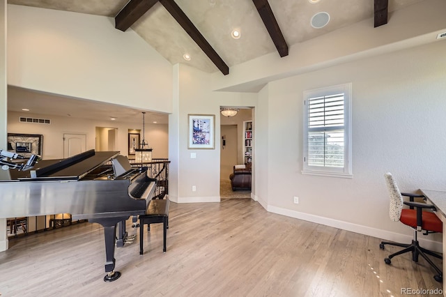 living area with visible vents, wood finished floors, beamed ceiling, baseboards, and an upstairs landing