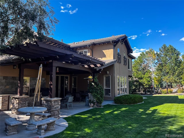 back of house with a pergola, stucco siding, a yard, and a patio area